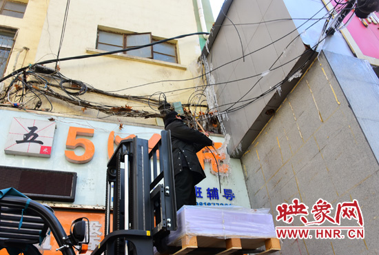 站在叉車(chē)升高的叉板上除冰 站在叉車(chē)升高的叉板上除冰