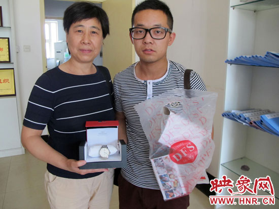 失主王女士從B11車長吳杰手中拿回自己幫朋友捎的免稅名表 失主王女士從B11車長吳杰手中拿回自己幫朋友捎的免稅名表