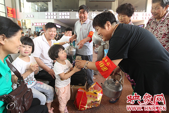 老年雷鋒團”志愿者在候車廳為旅客送水。