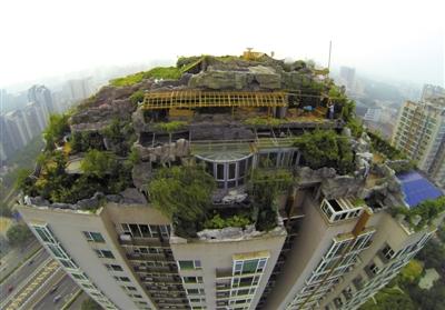 　　昨日，身穿橘黃色馬甲的工作人員在人濟山莊樓頂拆除違章建筑。新京報記者 吳江 攝