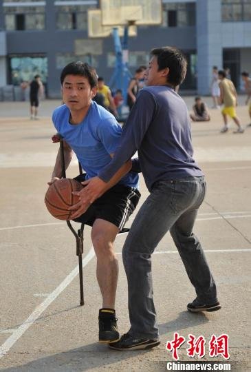 圖為拄著拐杖的瞿詩(shī)濤和同學(xué)搶球。劉占昆攝