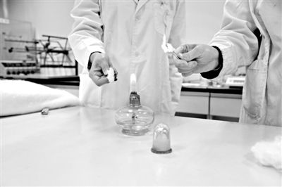 實(shí)驗(yàn)人員操作的燃燒檢測(cè)法中，真蠶絲離開火焰就熄滅(左)。