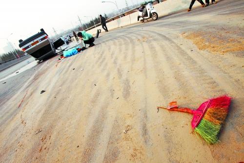 被撞的環(huán)衛(wèi)工躺在地上，身上蓋著藍(lán)色布?jí)K，現(xiàn)場(chǎng)除散落的汽車(chē)碎片外，還留有被撞斷的掃帚。