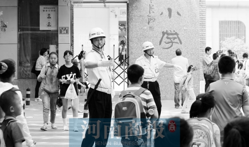 伊河路小學門口，兩名巡防隊員護送學生過馬路