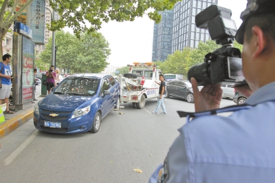 在金水路，交警對在機動車道違法停放的車輛施行拖離