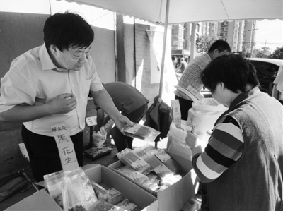 昨日，河南企業(yè)家劉春喜在京“練攤”，為顧客挑選綠豆。新京報記者 張玉學 攝