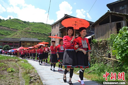 圖為新娘身著瑤族盛裝在伴娘和親友的陪伴下“出嫁”。中新社發(fā) 韋吉陽 攝