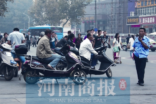 　火車站廣場北側(cè)，幾輛摩的正在等客