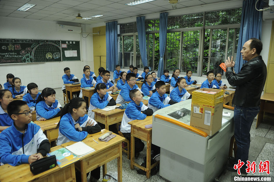 圖為老師正在向同學(xué)們講解用非智能手機(jī)對(duì)他們的好處。