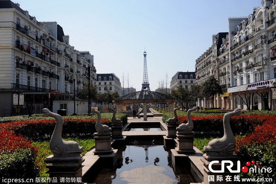 　2014年3月21日，杭州天都城，農(nóng)民在山寨埃菲爾鐵塔下耕作。圖片來源：東方IC