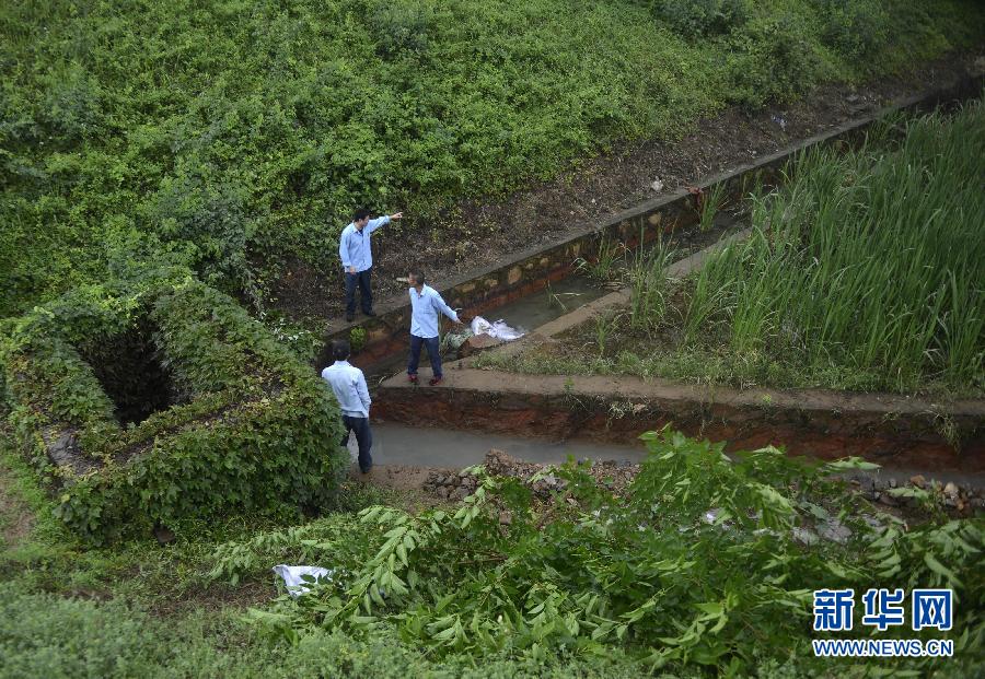 5月18日，工作人員在槽罐車泄漏現(xiàn)場(chǎng)附近的水渠邊查看情況。