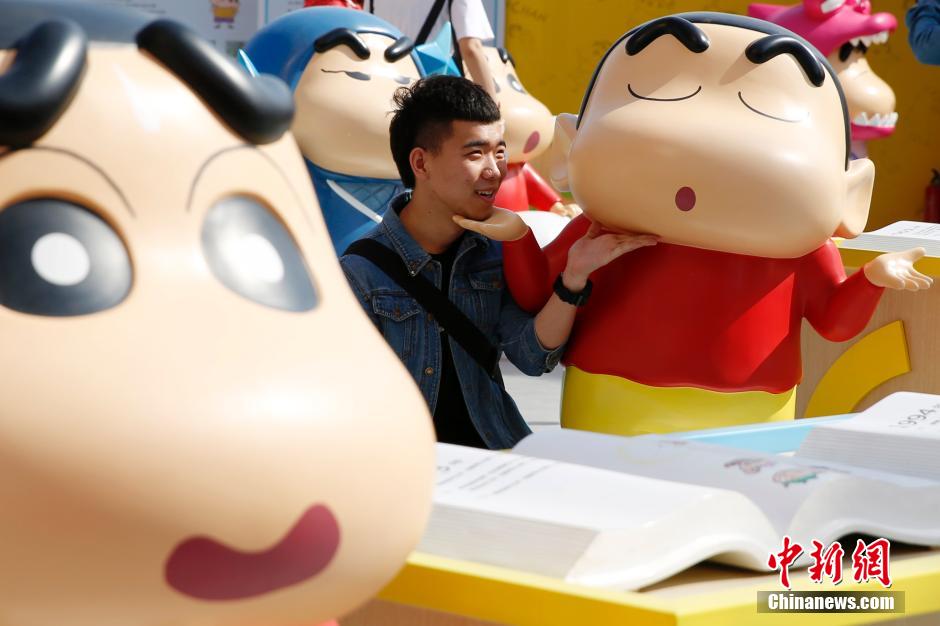 4月22日，游客與蠟筆小新合影?！跋灩P小新25周年紀(jì)念特展”日前在北京開展，吸引了不少市民游客。