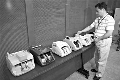 昨日，央行工作人員用各種驗(yàn)鈔機(jī)對C1F9假幣進(jìn)行測試，機(jī)器均能及時作出異常報(bào)警反應(yīng)。新京報(bào)記者 浦