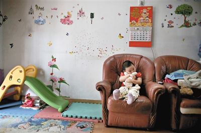 6月14日，未婚媽媽于軍的家里。女兒悅悅抱著兔子玩偶，在聽媽媽手機(jī)上的兒歌，這個(gè)4歲女孩喜歡兔子。