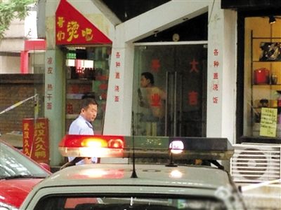 闖入面館的持刀男子與趕來的民警隔著玻璃門對峙，后店內(nèi)一名女童被其劫持。網(wǎng)友供圖
