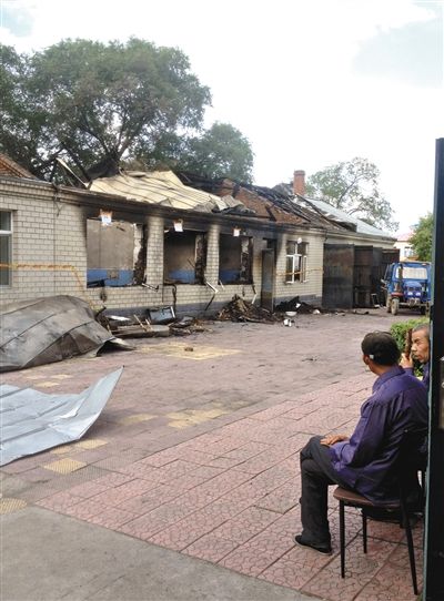 7月27日，海倫聯(lián)合敬老院內(nèi)，幾名老人看著對面被燒毀的特護(hù)病房。新京報(bào)記者 涂重航 攝