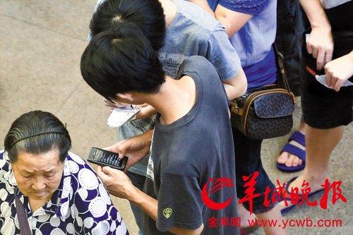 排隊的“黃?！备魇謭?zhí)一疊白紙，上面寫好了要掛號的人的信息，包括姓名、電話、要掛的科室等。穿黑白花紋衣服的老婆婆正在排隊掛號