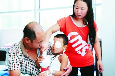 斌斌手術(shù)后第一天恢復(fù)良好，斌斌父母在用玩具逗他開心供圖/嚴益