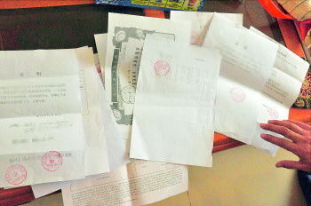 60歲的市民仇先生為了辦理公證所需的這些證明材料,半個月時間里跑了30多趟腿。記者　李萌博　攝