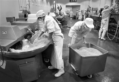 昨日，位于順義李遂開發(fā)區(qū)的慶豐包子鋪配送中心生產(chǎn)車間，工人們正在斬拌胡蘿卜餡料。