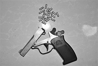 警方從搶劫嫌疑人處起獲的贓款和發(fā)令槍、子彈。警方供圖