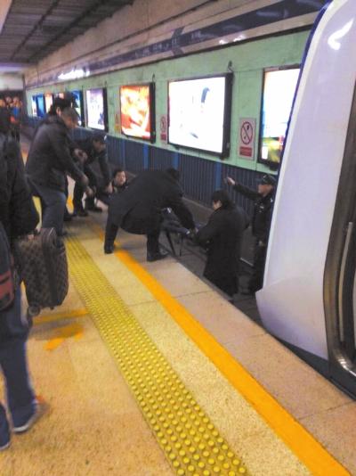 地鐵工作人員將林某從站臺下救起。網(wǎng)友供圖