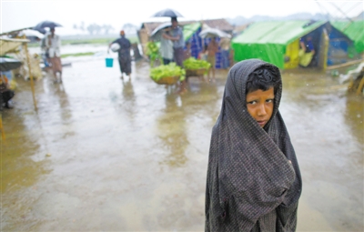 5月14日，緬甸若開邦實兌難民營，羅興亞族難民在雨中行走。熱帶風(fēng)暴“馬哈森”即將登陸緬甸，這里的難民開始乘船撤離。