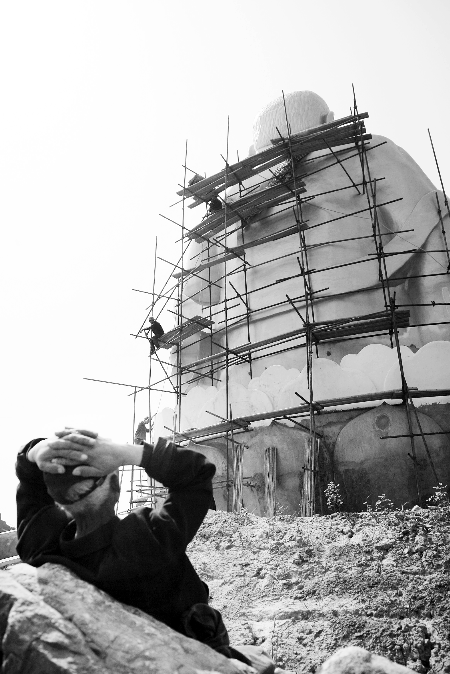 今年4月26日，工作人員將帆布蓋在“佛像”頭像上