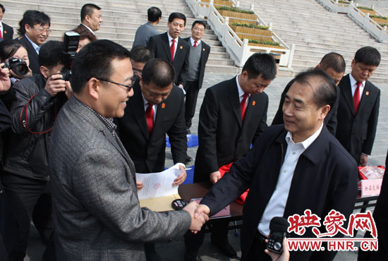 在新密市法院，省高院院長張立勇為拍得轎車的陳先生發(fā)放車鑰匙。