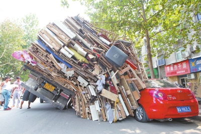 紅色小轎車(chē)被砸，卡在路邊動(dòng)彈不得。