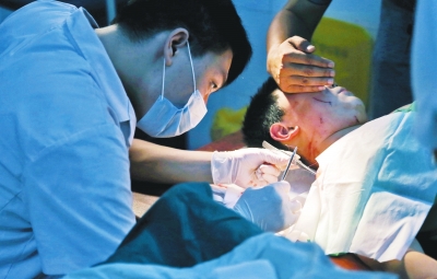 孩子身上有7道傷痕，其中兩道需要縫合，其他的均為擦傷，醫(yī)生正對(duì)他施治。