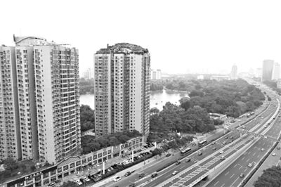 昨日，人濟山莊小區(qū)，與其他樓相比，B棟樓頂層天臺上違規(guī)建造了一棟兩層小樓，假山大樹俱全。新京報記者