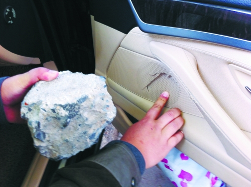 “飛”進寶馬車內的大石塊,將寶馬車的車門內飾板砸爛。