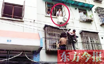 施救現(xiàn)場，劉鵬（圈內）先用繩子捆住老太確保安全 勞動報記者 郭娜 供圖