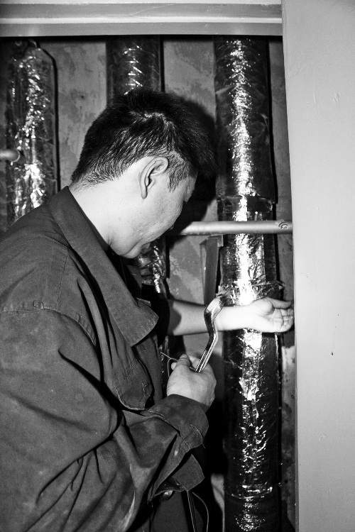 苗師傅一邊進(jìn)行維修，一邊用耳機(jī)接聽市民的電話。