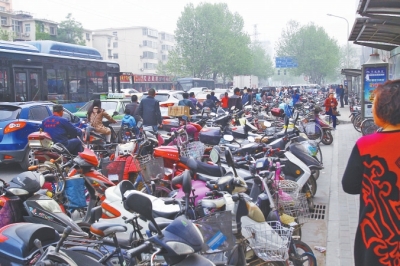 省人民醫(yī)院北門，路邊的公交站牌處停滿非機(jī)動(dòng)車，上、下客只能在快車道上。