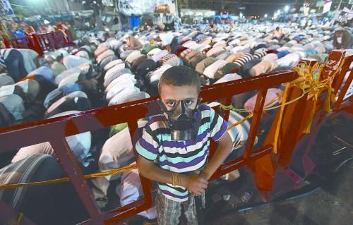 當(dāng)?shù)貢r(shí)間28日晚，在埃及開(kāi)羅納賽爾城，一名小男孩頭戴防毒面具參加穆兄會(huì)的集會(huì)示威。