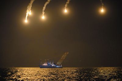 22日，搜救人員在照明彈的光亮下連夜搜救。