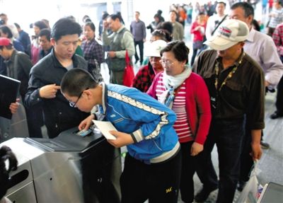 去年5月5日，14號線園博園站，乘客刷卡出地鐵。北京公交地鐵將實(shí)行計(jì)程票制，多乘坐多付費(fèi)。