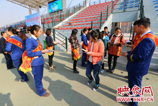 活動(dòng)現(xiàn)場工作人員給同學(xué)們發(fā)放宣傳冊(cè)、環(huán)保袋。