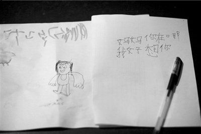 名叫袁明燕的小姑娘用筆在紙上不斷寫“媽媽”二字。