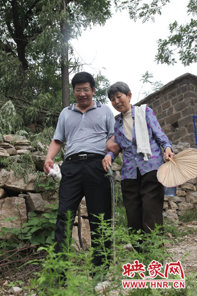 海付恒攙著患有腿部風濕性關(guān)節(jié)炎的劉梅英下山