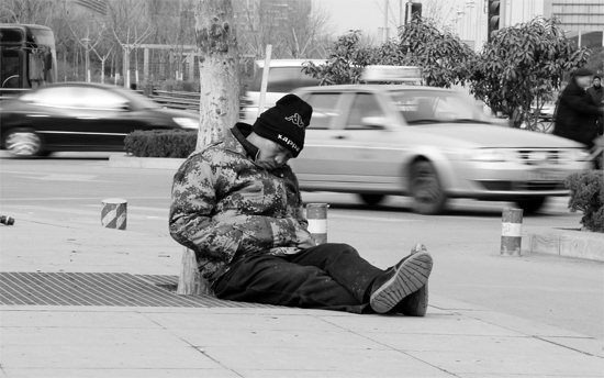 2月2日，鄭州市中州大道農(nóng)業(yè)路立交橋下，50歲的王文德打算在臨近春節(jié)前再接些零活兒，由于疲憊，他睡著