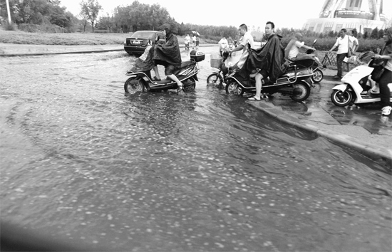 8月7日，鄭州一場(chǎng)暴雨，鄭州多處干道被淹，市民行路如過河