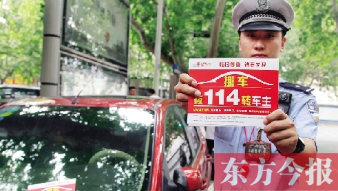 8月27日，鄭州市緯一路與經(jīng)七路交叉口，交警將“挪車請撥打114轉(zhuǎn)車主”的提示牌放在路邊?？康能嚿? width=