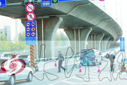 交警在東風(fēng)路從北向南上橋口處擺上反光錐，間歇放行