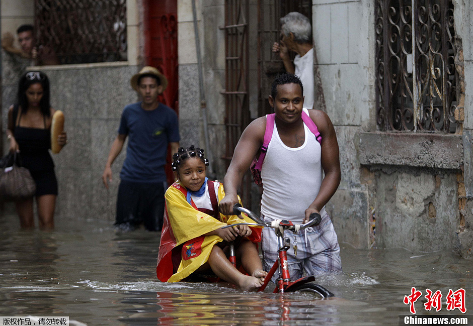 圖為哈瓦那民眾冒水出行。