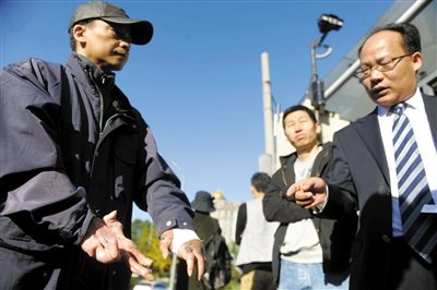 常林鋒在法院外展示雙手，他稱被燙傷的手因刑訊逼供且未得到及時(shí)救治