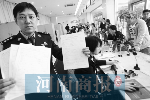 　民警左手拿的是新申請表，右手拿的是三份老申請表 王春勝/攝
