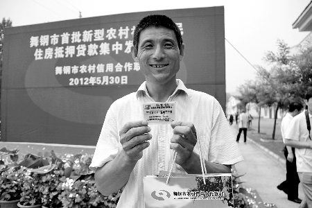 領(lǐng)到貸款，農(nóng)民開(kāi)心地笑了。